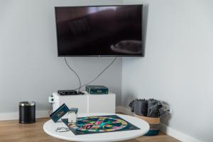 a table with a flat screen tv on a wall at Ilha Hostel & Suites in Ponta Delgada