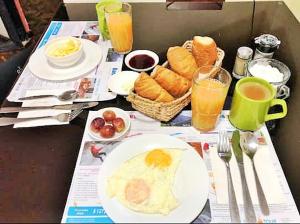 a breakfast table with a plate of food and drinks at Hostal Monte Carmelo in Baños