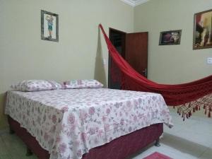 a bedroom with a bed with a red mosquito net at Chalés Porto do Céu in Aracati