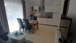 a kitchen with a table and chairs and a dining room at Apartamenty Dżemejra - Jumeirah in Darłowo
