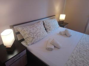 ein Schlafzimmer mit einem Bett mit zwei Handtüchern darauf in der Unterkunft Bohemian Rhapsody NBG in Belgrad