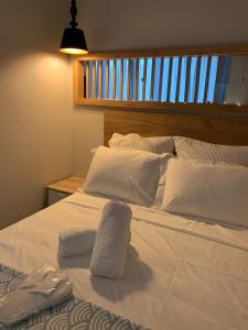 un grande letto bianco con cuscini bianchi di Main Square Flat - LUXURY APARTMENTS XANTHI LAX a Xánthi