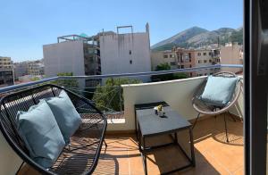 un balcone con due sedie e un tavolo su un balcone di Main Square Flat - LUXURY APARTMENTS XANTHI LAX a Xánthi