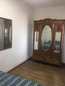 um quarto com uma cómoda de madeira e um espelho em Experiencia cultural rosarina em Rosário