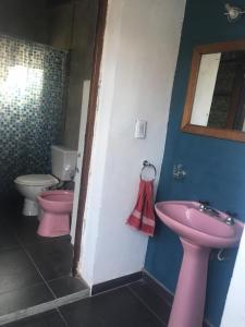 uma casa de banho com 2 WC cor-de-rosa e um lavatório. em Experiencia cultural rosarina em Rosário