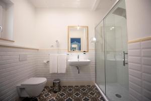 a bathroom with a sink and a toilet and a shower at Sui Generis Tropea Luxury Rooms in Tropea