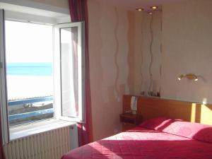 a bedroom with a bed and a window with the ocean at Alpha Ocean in Saint Malo