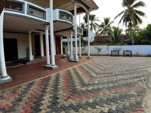 un edificio con una alfombra colorida delante de él en A and D Holiday Inn en Anuradhapura