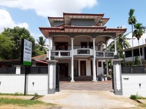 ein großes weißes Gebäude mit einem Schild davor in der Unterkunft A and D Holiday Inn in Anuradhapura