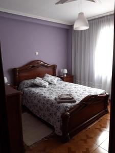 een slaapkamer met een bed met een deken en een raam bij PISO CERCA DEL SARDINERO in Santander