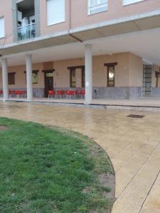 un edificio vacío con mesas y sillas rojas en Albergue Santo Tomás de Canterbury, en León