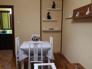 een eetkamer met een witte tafel en stoelen bij PISO CERCA DEL SARDINERO in Santander