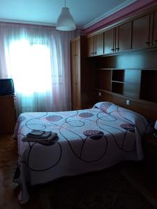 een slaapkamer met een bed en een raam bij PISO CERCA DEL SARDINERO in Santander