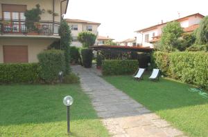a yard with two lawn chairs in the grass at Affittacamere Loretta in San Giuliano Terme
