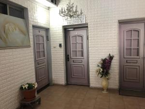 a hallway with two doors and a vase of flowers at Star Guest- House in Or Yehuda