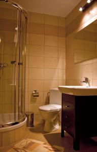 a bathroom with a toilet and a shower and a sink at Hotel Pojezierze in Szczecinek