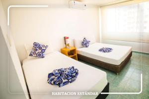 A bed or beds in a room at Hotel Portobahia Santa Marta Rodadero