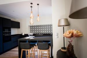 a kitchen with a black table and chairs at La Suite d'Elisabeth in Sarlat-la-Canéda +12 photos