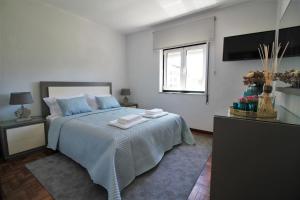 a bedroom with a bed with two towels on it at Casa dos Ouriços in Ponte de Lima