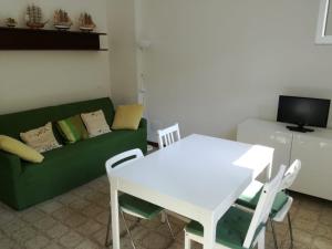 a living room with a white table and a green couch at Gianna's cosy apartment in Monterosso al Mare