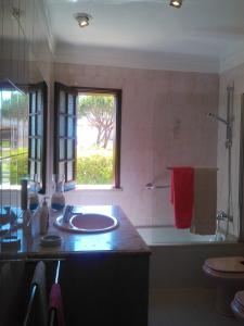 baño con lavabo, bañera y ventana en Alsouk, en Vilamoura