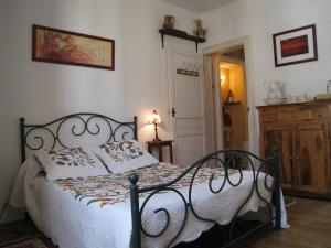 1 dormitorio con 1 cama con edredón blanco en Le Petit Quernon en Angers