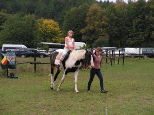 a woman is riding a horse while another woman is walking at Agroturystyka Pod Rumakiem in Chęciny