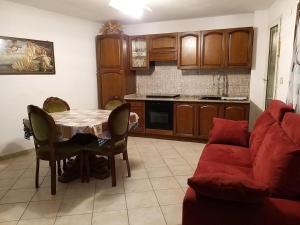 Una sala de estar con una mesa y un sofá rojo. en Casa singola, en Orosei