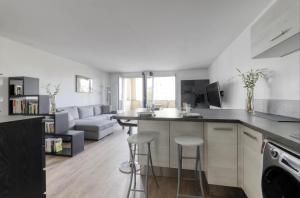 una cucina e un soggiorno con bancone e sgabelli di 123home-The Outlet a Serris
