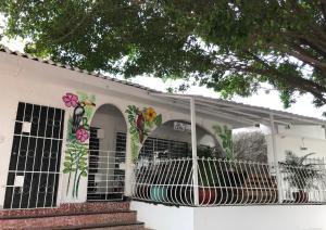 ein weißes Haus mit seitlich bemalten Blumen in der Unterkunft La Quinta Bacana in Barranquilla