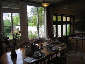 mesa de comedor con sillas y ventana grande en Le Petit Quernon en Angers