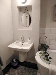 uma casa de banho com um lavatório, um WC e um espelho. em Aubrey Cottage em Cowbridge