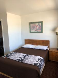 a bedroom with a bed and a night stand with a lamp at Payette Motel in Payette