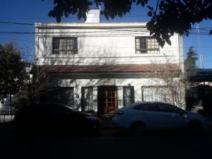 a white car parked in front of a white building at Departamentos del centro in Villa Mercedes