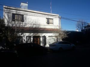 a white car parked in front of a white building at Departamentos del centro in Villa Mercedes