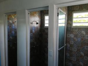 a bathroom with a shower and a glass door at Park Hostel in Port-au-Prince
