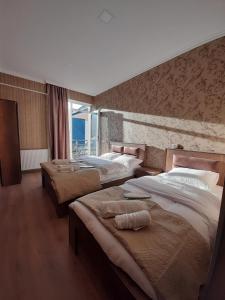 um quarto com três camas num quarto em Sky Star em Kazbegi