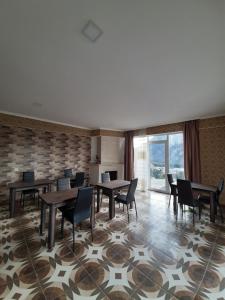 una sala da pranzo con tavoli, sedie e una grande finestra di Sky Star a Kazbegi