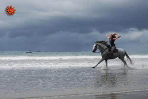 Una mujer montando a caballo en la playa en Locanda Samara Beach, en Sámara