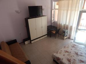 a bedroom with a couch and a tv on a cabinet at Dunav Str. in Ravda