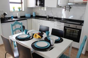uma cozinha com uma mesa com pratos e fruta em Beach Front Apartment 2 em Sagres