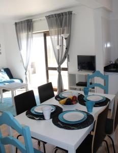 a dining room with a white table and chairs at Beach Front Apartment 2 in Sagres