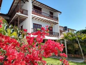 a white building with red flowers in front of it at Casona El Retiro Barichara in Barichara