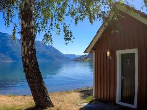 
a wooden cabin with a view of a lake at Dalsøren Camping og hytter in Luster

