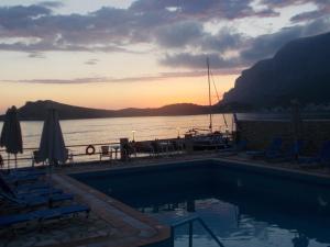 a swimming pool with a view of the water and a boat at Agelica Apartments in Kalymnos