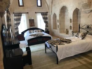a bedroom with two beds in a room with windows at Kasr-i Abbas Hotel in Mardin