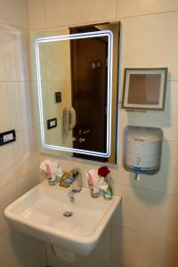 
a bathroom with a sink, mirror, and soap dispenser at Petra Boutique Hotel in Wadi Musa
