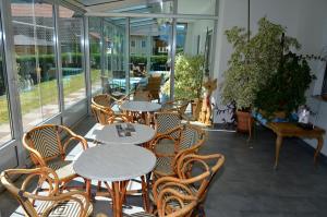 a patio with tables and chairs and windows at Pension Pichler in Chienes