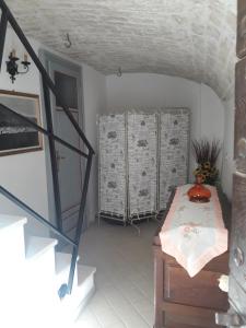 Habitación con escalera y habitación con mesa. en Casa vacanze Le Dimore del Mercante en Luco neʼ Marsi