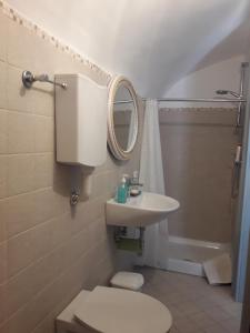 a bathroom with a toilet and a sink and a mirror at Le dimore del Mercante in Luco neʼ Marsi +20 photos